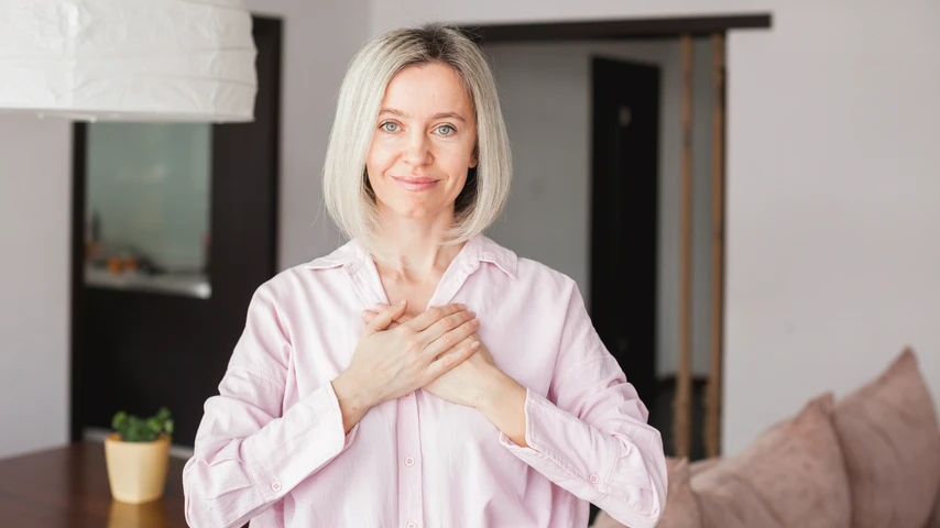 A smiling women with her hands placed over her heart